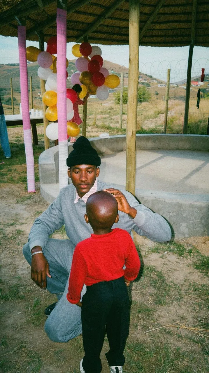 A young man crouching to talk with a small boy